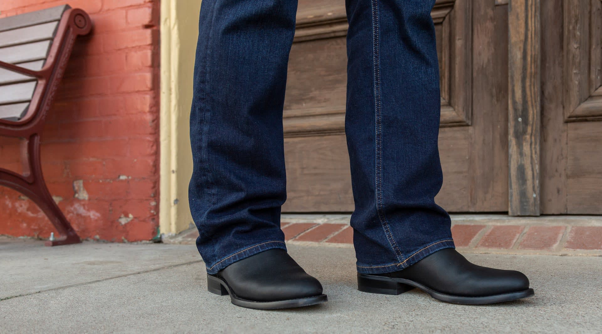 man in black boots and jeans